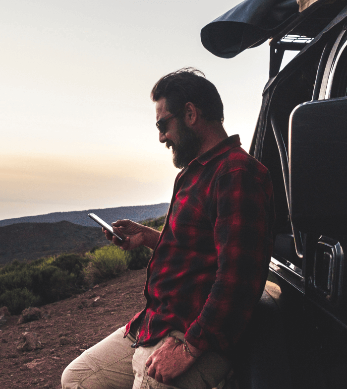 Balance Hybrid Adobe Commerce Case Study, REDARC Electronics - person in red and black flannel shirt standing against REDARC vehicle